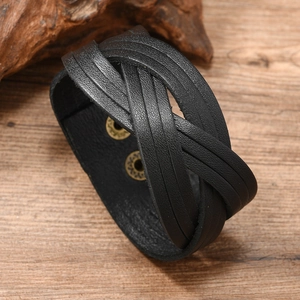 Detail of hand-woven black leather wide bracelet with adjustable metal snap buttons