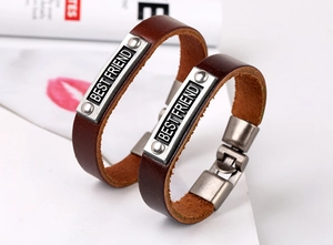 Detail of two vintage brown leather bracelets with Best Friend engraved silver plates