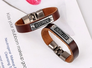 Close-up of retro brown leather bracelets with BEST FRIEND engraved metal plates