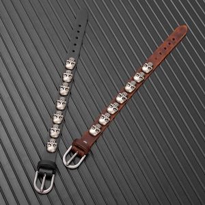 Detail of adjustable leather punk bracelets with silver metal skull studs and buckle