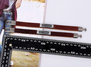Detail view of vintage leather bracelets with Best Friend engraving and buckle closure