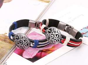 Detail of vintage leather bracelets with braided ropes and engraved metal centerpieces