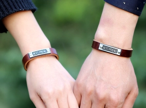 Close-up of retro brown leather bracelets with Best Friend engraved metal plates