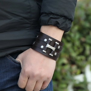 Detail of multi-layer wide brown leather punk bracelet with silver metal studs and rivets