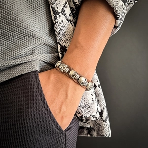 Punk leather bracelet for men featuring metallic silver skulls and adjustable brown strap