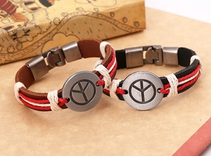 Nahaufnahme von Vintage Lederarmbändern mit Metall-Friedenssymbol und sicherem Verschluss