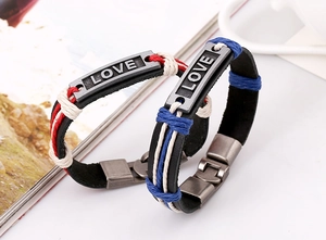 Detail von handgewebten Lederarmbändern mit LOVE-Gravur und Vintage-Metallschnalle