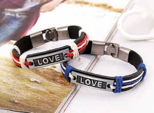 Detail von handgewebten Lederarmbändern mit LOVE-Gravur und farbigen Kordelakzenten