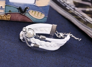 Gros plan du bracelet multicouche en cuir tressé blanc avec signe infini et cœur perle