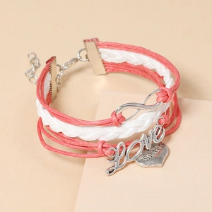 Détail du bracelet en cuir tressé rose avec lettres Love et breloque en cœur Sister