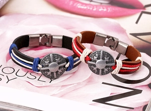 Detail of bohemian braided leather bracelets with vintage alloy relief and metal clasp