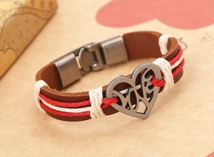 Dettaglio del bracciale in pelle marrone con ciondolo a cuore e incisione LOVE