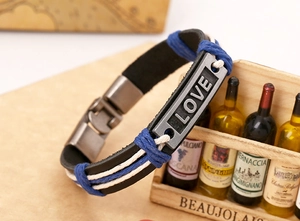 Nahaufnahme eines mehrlagigen Lederarmbands mit einer Vintage-Metallplatte mit LOVE-Schriftzug