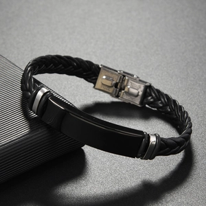 Macro shot of men's black braided leather bracelet featuring a polished black metal plate