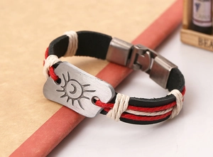 Vue macro d'une plaque soleil et lune sur un bracelet en cuir tressé vintage avec cordes