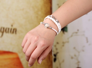 Détail d'un bracelet tressé blanc multicouche avec breloque infini et cœur en perle
