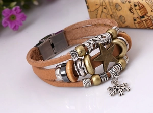 Close-up of multilayer leather bracelet with bronze star, moon pendants and metallic beads