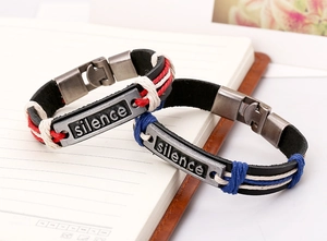 Détail de bracelets en cuir tressé avec plaques en métal vintage gravées silence