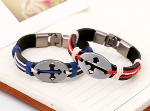 Detail of vintage braided leather bracelets with hollow cross oval metal charms