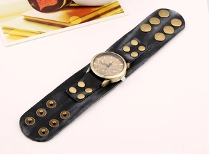 Dettaglio dell'orologio punk vintage con cinturino largo in pelle nera e rivetti in ottone