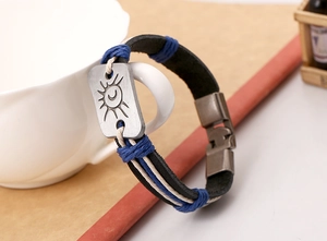 Détail du bracelet en cuir tressé avec gravure soleil et lune sur fermoir vintage
