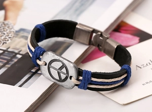Détail du bracelet en cuir tressé de style bohème avec un charme symbole de paix