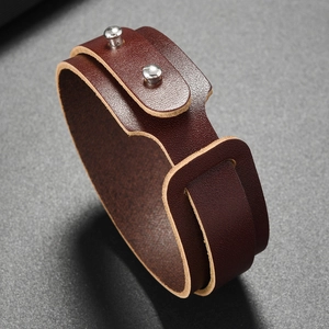 Close-up of double-wrap brown leather bracelet with silver metal studs and retro punk design
