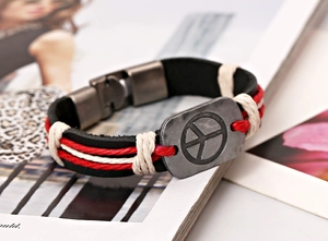 Détail d'un bracelet en cuir tressé avec signe de paix et cordelette rouge et blanche