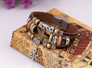 Close-up of multilayer leather bracelet with bronze star, snowflake charm, and beads