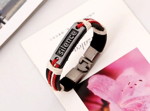 Détail d'un bracelet en cuir tressé avec gravure Silence sur plaque métallique