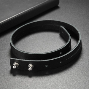 Detail of adjustable double-wrap black leather bracelet with silver metal mushroom studs