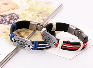 Close-up of woven leather bracelets with metallic charms and buckle clasp details
