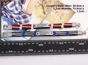 Close-up of woven leather couple bracelets with engraved love message and metal buckle