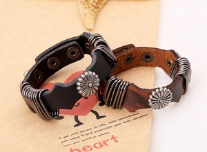 Close-up of punk leather bracelets with metal sunflower studs and snap buttons