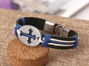 Close-up of leather bracelet featuring cross metal plate and woven rope accents