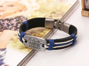 Detail of vintage braided leather bracelet with fish symbol metal plate and metal clasp
