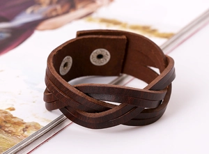 Macro detail of braided brown leather bracelet with secure metal snap buttons for men
