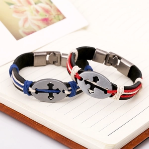 Retro leather bracelets for couples featuring cross charms on a notebook background