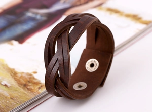 Detail of dark brown braided leather bracelet with silver adjustable metal snap buttons