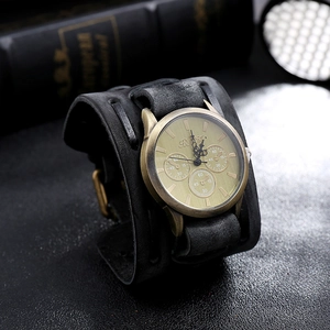 Macro detail of a vintage wide leather watch band with decorative bronze dial