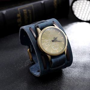 Detail of vintage bronze watch case with champagne gold dial on wide blue leather cuff strap