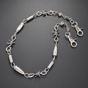 Punk silver thorn wallet chain with bullet and dice charms on a dark textured surface