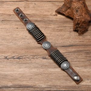 Detail of adjustable leather bracelet with sunflower rivets on wooden background