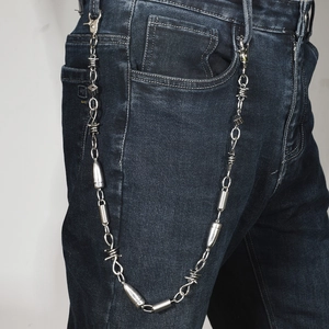 Punk style silver metal trouser chain with bullet charms and dice on dark denim jeans