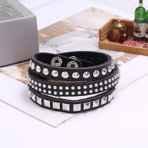 Close-up of punk triple-wrap leather bracelet featuring mixed silver metal studs
