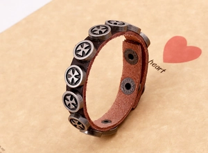 Detail of punk leather bracelet with vintage silver cross studs and snap buttons