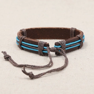 Handmade vintage woven leather bracelet with blue wax ropes on rustic linen background