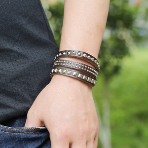 Close-up of a three-layer punk brown leather bracelet with silver metal rivets on a wrist