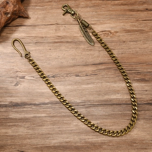 Retro bronze wallet chain with feather pendant and lobster clasp on wood texture