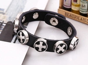 Detail of a black punk leather bracelet featuring silver cross patterned metal studs
